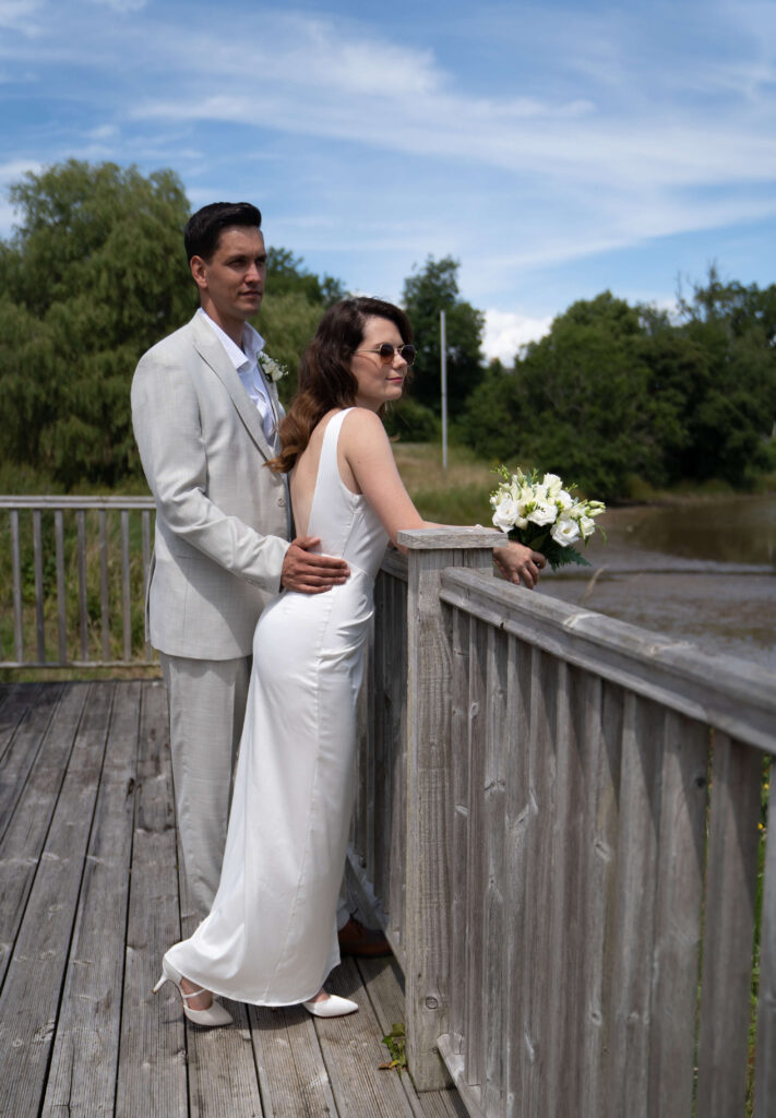 A bride and a groom standing by the lake om the Isle of Wight