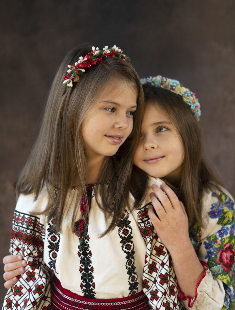 family portrait of two sisters wearing Ukrainian national dresses