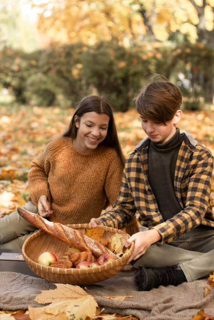 two teen-aged kids on a picnic in the Autumn park