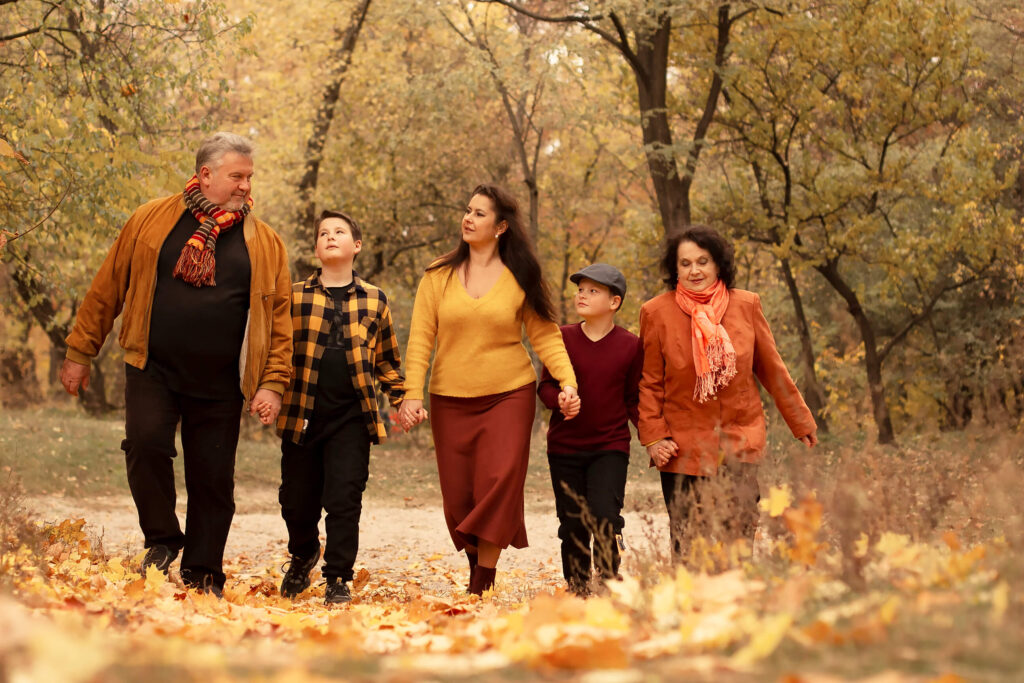 A family walking hand in hand in the Autumn park