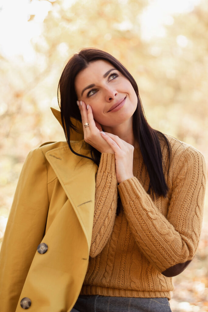 a young woman in a yellow sweater and coat in Autumn