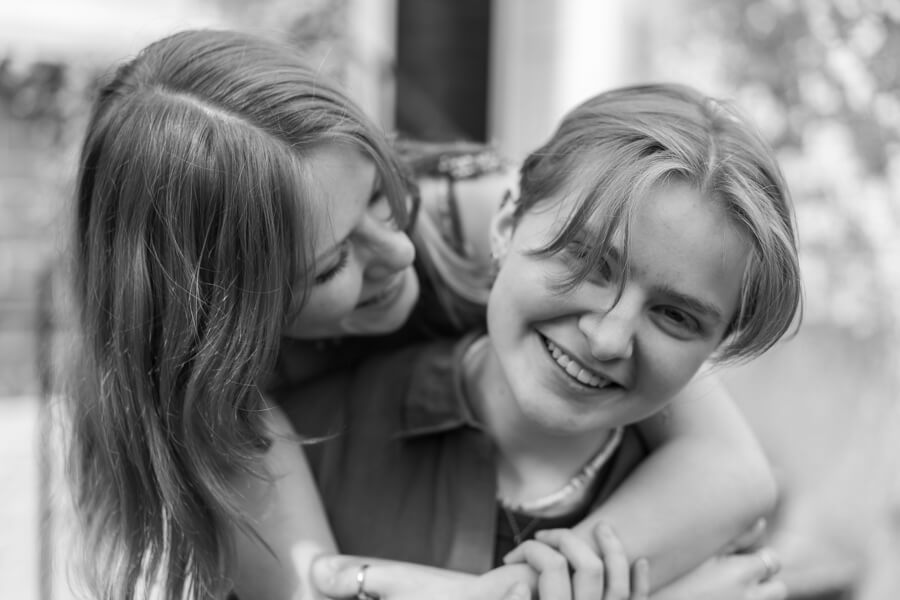 a candid image of two sisters laughing and hugging